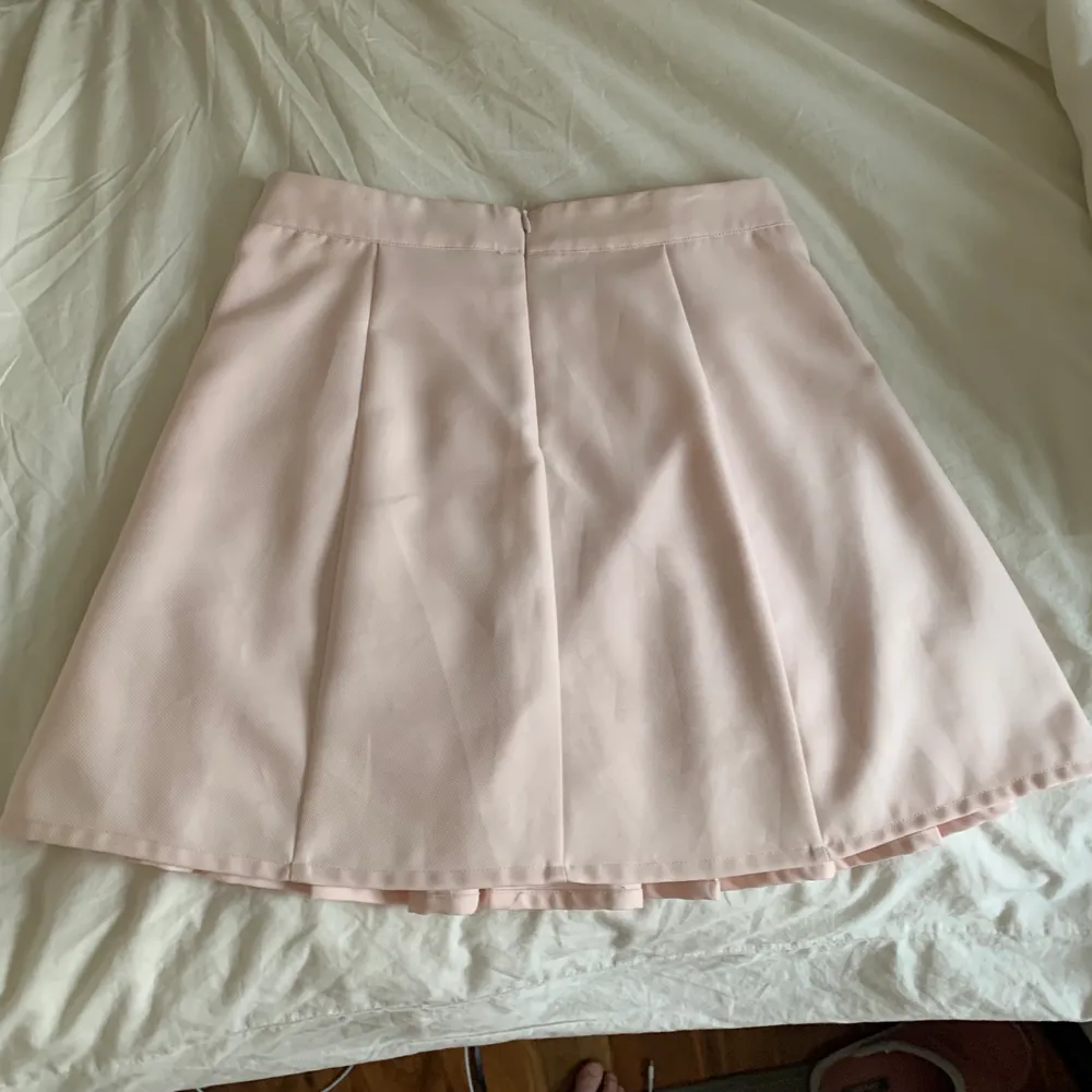 Gullig helt oanvänd ljusrosa kjol från Gina Tricot som passar perfekt till sommaren! Dock är den för stor i midjan för mig vilket gör att jag måste hålla i kjolen för att den ska sitta snyggt vilket man kan se på bilderna. På sista bilden kan man se hur den ser ut bak. Storlek 36, jag brukar oftast har 34/xs i kjolar💕💕. Kjolar.