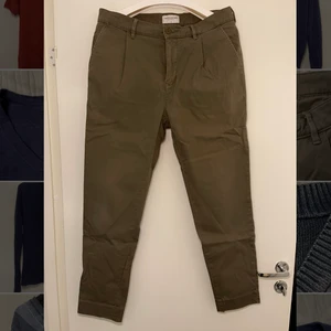 Plisserade högmidjade gröna chinos - Högmidjade gröna chinos med plissering från These Glory Days. Frakt tillkommer.