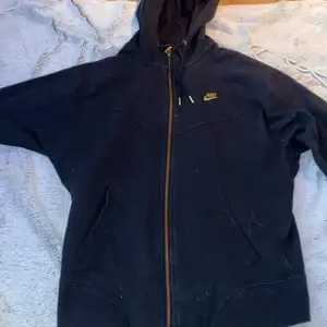 Svart Nike ziphoodie med guldiga detaljer 