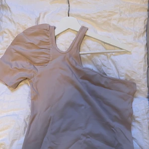 Tröja med bar axel från NAKD - Topp med bar axel från NAKD, i färgen beige storlek S. Aldrig använd.