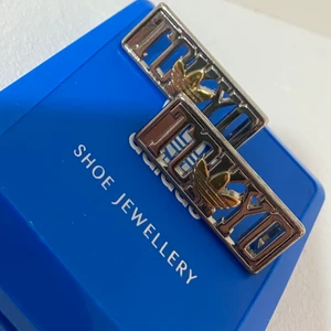 Adidas skosmycke  - Fästes på skosnören. 