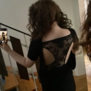 Söt topp  - Söt svart topp som inte riktigt passar längre, är öpppen i ryggen med ett spetts mönster.