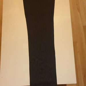 Mörkblåa kostymbyxor - Mörkblåa kostymbyxor med vita ränder från Jack&Jones. Aldrig använda med tagsen kvar, storlek 30 i midjan och 32 längd.