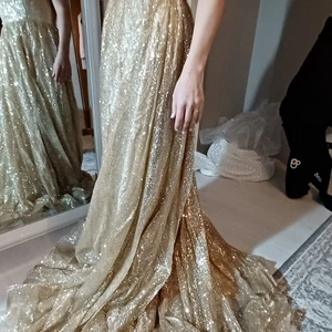 Festklänning  - Helt oanvänd festklänning. Bröllopet jag skulle ha den blev inställt. Skräddarsydd. Glitter jättemycket.  Har video och massor av bilder. Skriv gärna om du är intresserad. Köparen betalar frakt.