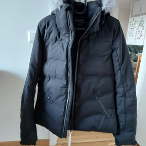 Oysko winter jacket / vinter jacka - En mycket bra vinter jacka i svart med en huvi,som kan tas bort. Jackan anpassat som elegant jacka till vardagen + sportig när det behövs ( har extra skydd mot vind och bra för att åkaskidor). Använde bara enstaka ggr. Ganska ny i skick. Ord. Pris 1399 sek