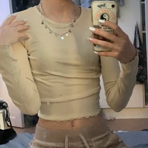 Gina topp - Skit snygg långarmad tunt ribbad topp med hål i ryggen som gör den extra snygg, Använd någon gång i sommar men annars ny, inga defekter. Strl xxs men passar även xs eller liten s då den är mycket stretchig. Köpter för ca 170? säljer för 90kr pris kan diskuteras