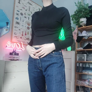 Tight svart polocrop - Croped polo av svart tight material. Textilen är randig vertikalt. 