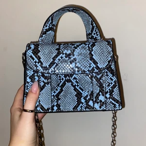 Crossbody bag - blått ormskinn  - Crossbody bag i blått ormskinn med silvrig kedja. Väskan har två halvstora fack och är köpt på Zara för ca 360kr. Säljes då den inte kommer till användning därav är den även i bra skick. Vid frågor är det bara att skicka ett meddelande💗
