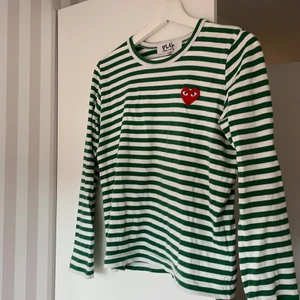 Comme des Garçons play t shirt - En långärmad t shirt från Comme des Garçons play i storlek M, men sitter mer som en S. Grön och vit randig. Knappt använd så i riktigt bra skick! 