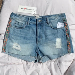 Jeans shorts - Shorts från Hm Coachella Collection med slitningar och detaljer på sidorna. Oanvänd med lapparna kvar. Haft dem ett bra tag men sträckte mig aldrig efter dem i garderoben så nu förtjänar de en ny ägare