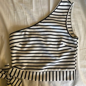 One shoulder-topp från Nakd i strlk s - Randig one shoulder-topp från Nakd med knytning på sidan säljes. Toppen är i strlk s men passar även någon med strlk m. Endast använd ett fåtal gånger. Fin sommartopp gjord i ett ganska tjockt tyg vilket gör att kvalitén känns hög💘