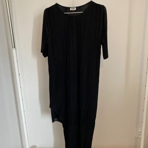 Plisserad asymmetrisk klänning - Plisserad asymmetrisk klänning från Weekday med extratyg under så det inte syns igenom. Storlek M men passar även S och L beroende på hur man vill den ska sitta
