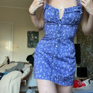 Lila/blå klänning från sunifty  - En jättefin lila/blå klänning med blomdetaljer jag köpt från sunifty. Den går att knäppa och är jättefin nu för sommaren. Kan mötas upp i Stockholm eller frakta men då kostar frakten extra ca 40kr