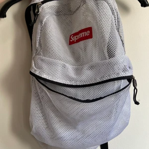 Supreme ryggsäck  - Andvänt några gånger , äkta och köpt i USA! Den är i nät med vitt och röd logga! En liten ficka på utsidan och alla blixtlås fungera väl. Säljer för 500kr men kan diskutera priset. Har dock en liten fläck på baksidan av kanten men är nästan inte synlig 