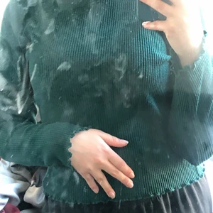 Långärmad tröja - kort grön tröja med volanger på ärmarna. 