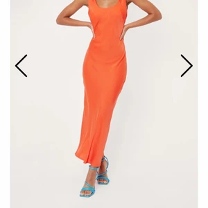 Orange satin klänning - Orange klänning i satin-liknande material. Köpt på Nastygal för balen men kom aldrig till användning då jag hittade en annan. Prislappen är kvar. Strl 34 men passar mig som brukar ha 36. Köpare står för frakt.