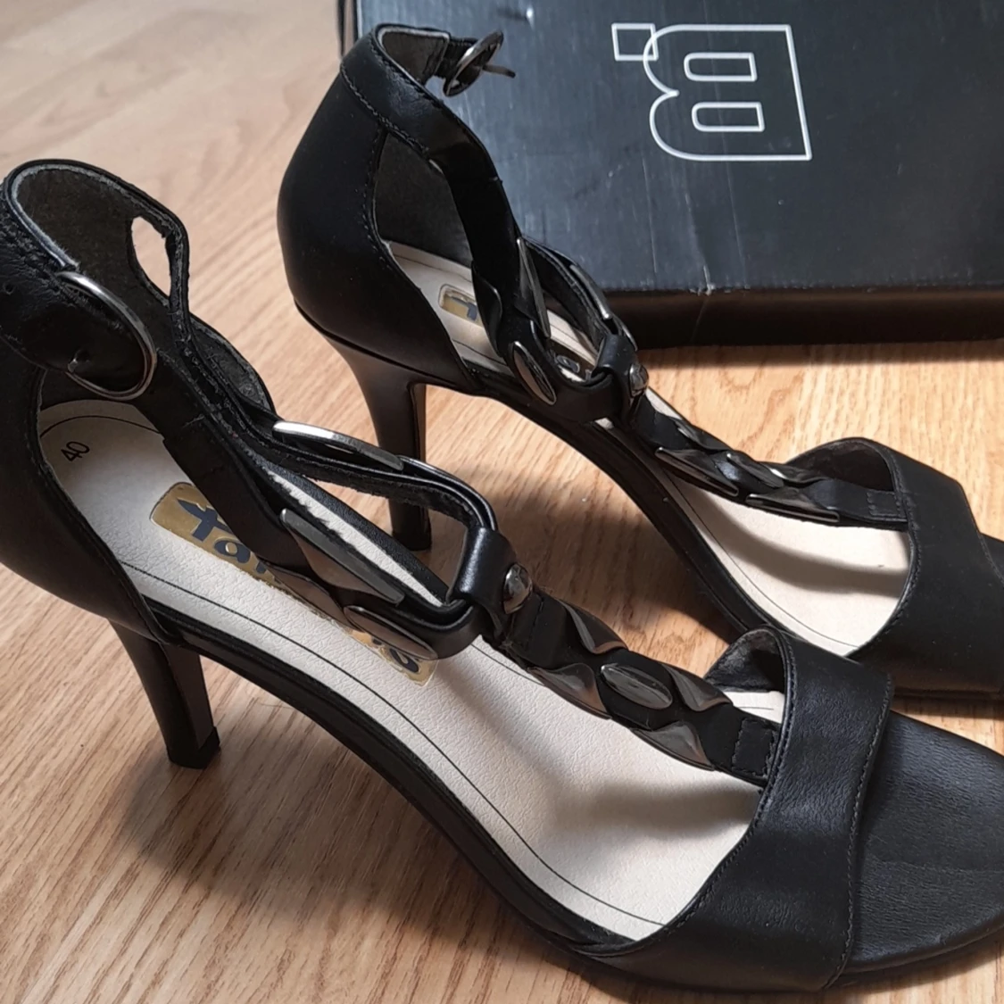 Små, svarta klackar med bronsaktiga detaljer på