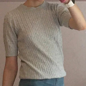 Grå topp - Ribbad, grå topp från Gina tricot som är använd mycket lite. Kan mötas upp eller frakta, men då står köparen för frakten.