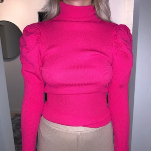 Neonrosa tröja med puffärmar  - Skitsnygg neoneonrosa tröja ifrån Zara. Har puffärm och krage som går att vika ner eller ha uppe. Är i ett ribbat väldigt skönt material. Storlek M men passar även S och L för att den är så stretchig. Är i bra skick då jag aldrig använt den.