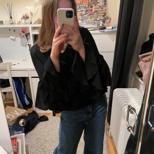 Volangtopp - Jättefin svart topp med volangärmar. Oanvänd! Fraktar eller möts upp i Stockholm