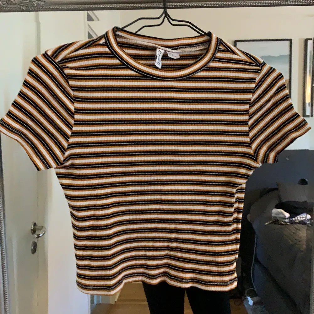 Randig T-shirt i orange, vitt och svart från H&M. Storlek M men känns mer som en XS/S beroende på hur man vill att den ska sitta. Jag är 167cm och bär i vanliga fall storleken XS/S eller 36. Obs! Katt finns i hemmet! ☺️. T-shirts.