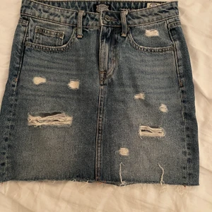 Jeanskjol - En superfint blå jeanskjol med slitningar. Har tyvärr blivit för liten för mig, storlek XS. Använd ett fåtal gånger. Köpare står för frakt (66kr och paketet går att spåra)💕