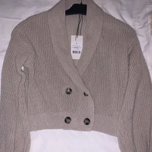 Beige kofta  - Helt oanvänt beige kofta, väldigt mysig och fräsch, kan hämtas upp i halmstad men går även att fraktas då står köparen för leveranskostnaden