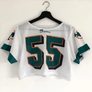 Croppad Jersey - Croppad Dolphins jersey köpt på Beyond Retro, säljes i det skick som den köptes. Storlek står inte men skulle säga att den passar strl XXS-M beroende på önskad passform 🤍 På mig (XS) sitter den ganska löst!
