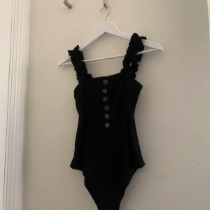 Svart body - En tajt svart body med lite volanger vid ärmarna. Från shein i storlek M men den känns som en S. Fin till sommaren