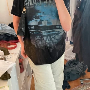 Oversize T-shirt  - Svart T-shirt med blått tryck, oversize på mig som är S 