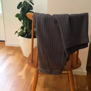 PrettyLittleThing Kostymbyxor  - Mellangråa kritstreck kostymbyxor i en mer oversized modell från PrettyLittleThing. Sparsamt använda men en övre knapp som har släppt. Går säkert att sy på igen. Storlek 34. Säljer för 40kr. Fraktas för 66kr. 😇