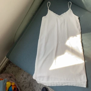 Vit klänning med spets - Vit klänning med spets vid dekolletage, rygg och även i nederkant. Från object i storlek 36.