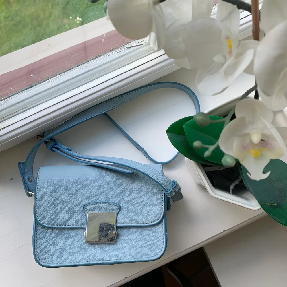 Ljusblå väska ifrån Zara med två olika band, ett basic ljusblått som matchar väskan och ett tjockt svart med blommor. Köparen står för frakt!😊. Väskor.