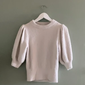 Naturvit tröja i fluffigt material - Naturvit tröja i ett fluffigt material, köpt på H&M och är använd ett par gånger. Resår i midjan och en något högre krage i nacken.