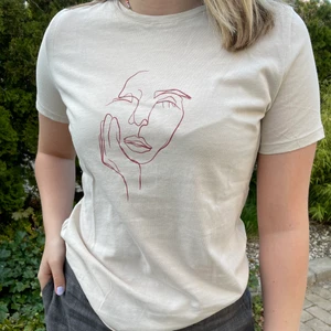 Beige T-shirt med tryck - En cool beige T-shirt med vinrött tryck från NAKD. Storlek S men passar M. Sparsamt använd. Säljs för att den inte kommer till använding. Frakt tillkommer 💜 