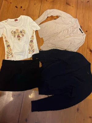 Klädpaket - Ett klädpaket med en cool T-shirt(strl 38), en mörkblå kofta(strl xl men passar mer som M), en beige kofta(strl s) och en svart miniskjol med detaljer(strl 36). Ops, T-shirten har en liten fläck. 