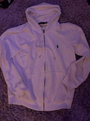 Vit zip hoodie från Polo Ralph Lauren - Säljer denna zip hoodie från Ralph lauren. Säljer den då den aldrig kommer till användning och är lite för liten. Storlek L men sitter bättre som M. Hör av er vid intresse så löser vi, priset ej hugget i sten vid snabb affär🙌