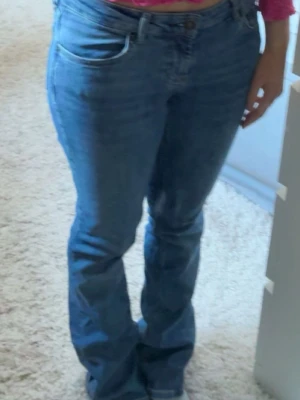 Blå bootcut Zara jeans med låg midja - Säljer ett par klassiska blå bootcut jeans ifrån Zara, som är i bra skick. Perfekta för en avslappnad och trendig stil💗