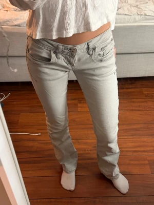 Ltb Valerie Jeans - Säljer ett par ljusgrå jeans med bootcut-modell och klassiska fem fickor. Jeansen har låg midja och snygga sömdetaljer både fram och bak. Perfekta för dig som gillar en avslappnad men ändå trendig look.