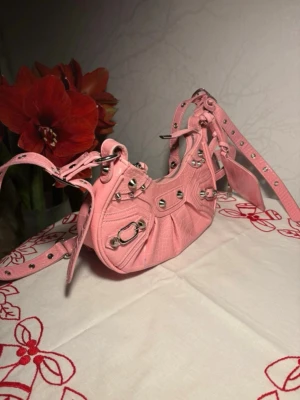 Balenciaga liknande väska - OBS!! Min kompis la ut samma artikel för ökad chans att sälja denna underbara väska så ingen av oss har snott någon annans bilder! Annars 😅 så är väskan mycket fin och i rosa färg med nitar och pris kan alltid diskuteras!💞🌷❤️💗🌺man kan ändra längden på bandet!🌷🌷🫶