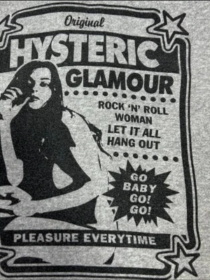 Grå hoodie från Hysteric Glamour - Snygg grå hoodie med dragkedja från Hysteric Glamour. Tryck på både fram- och baksidan med coola retroinspirerade motiv och text. Huva med dragsko och två fickor framtill. Perfekt för dig som gillar streetwear och unika plagg.