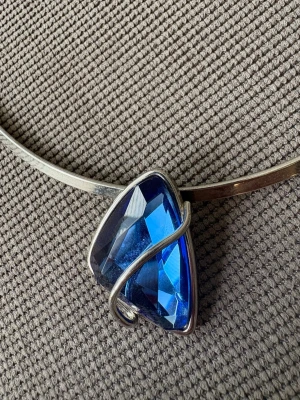 Halsband - Stelt halsband i nickelfri metall. Klarblått glashänge. 50cm runt om . Snygg accessoar 