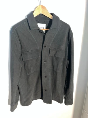 COS Overshirt - Hej, Säljer nu min väldigt snygga COS overshirt då den är för stor, tröjan är i väldigt bra skick och inga defekter. Kontakta mig vid frågor!🤩