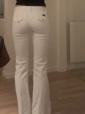 Seven lågmidjade bootcut jeans - Vita bootcut jeans från 7 for all men kind. Med snygg knäppning där fram och unika bakfickor. Nyskick, säljer då de är för små. 