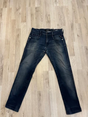 Mörkblå Replay jeans - Snygga mörkblå jeans från Replay från modellen anbass med raka ben och klassisk femficksmodell. Jeansen har subtila slitningar och kontrastsömmar för en archive look. Tillverkade i bomull med lite stretch för extra komfort. Pris ej hugget i sten och hör av er!