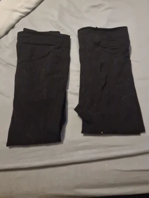 Svarta strumpbyxor, 2-pack - Två par klassiska svarta strumpbyxor i stretchigt material. Perfekta att bära under kjol eller klänning. Tightsen har en enkel, slät design utan synliga mönster eller detaljer. Märke och material är ej angivet.