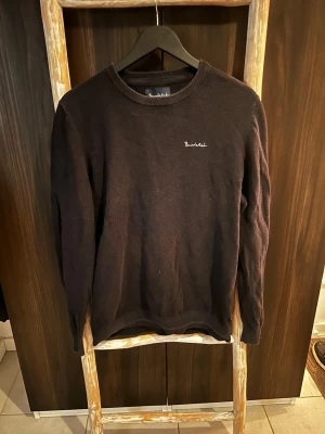 Svart tröja från Bondelid - En svart, stilren tröja från Bondelid med rund halsringning och diskret broderad logga på bröstet. Tröjan har en klassisk passform och är tillverkad i ett mjukt, stickat material som passar perfekt till jeans eller chinos.