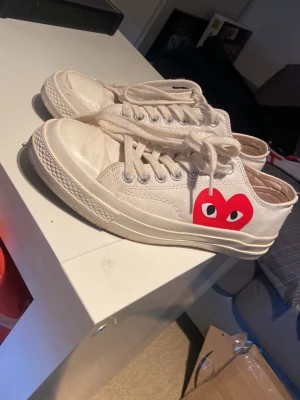 Vita Converse x CDG Play sneakers - Storlek 40 men sitter som 41 kanske till och med 42. Inga stora problem med skorna förutom lite smuts på skon, om det önskas så kan jag försöka få bort de innan jag skickar iväg de.
