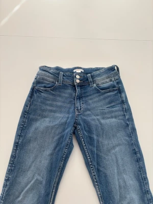 Midwaist jeans från Gina Young - Jeans från Gina Young med broderade fickor, mycket fint skick använda bara några gånger, ca 5 gånger. Mellan blå färg