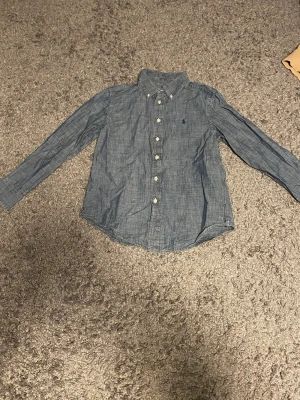 Grå/blå Ralph Lauren skjorta - Storlek 10-12 år, inköpt från kids brand store i Malmö. Bra skick.